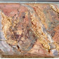 Figure 2. 10cm core at TDD-001 25m: Silicified breccia with stockwork banded veining.